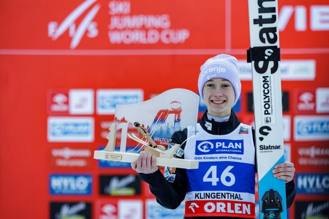 TOPSHOT - First placed Slovenia's Nika Prevc celebrates on the podium after winning in the Women's Individual Large Hill HS140 event of the FIS Ski Jumping World Cup in Klingenthal, eastern Germany on December 13, 2025. (Photo by JENS SCHLUETER / AFP)