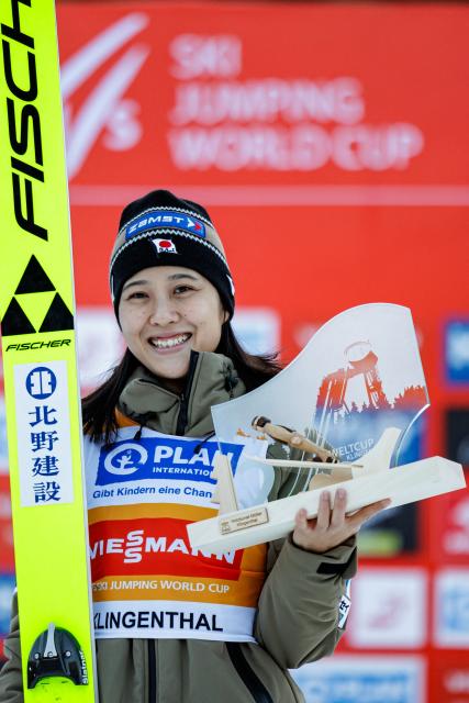Second placed Japan's Nozomi Maruyama celebrates on the podium after winning in the Women's Individual Large Hill HS140 event of the FIS Ski Jumping World Cup in Klingenthal, eastern Germany on December 13, 2025. (Photo by JENS SCHLUETER / AFP)