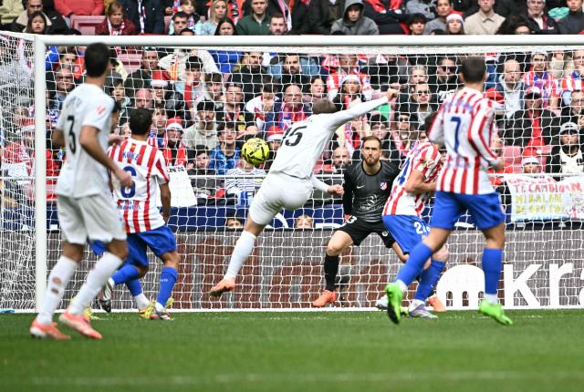 TOPSHOT - Valencia's Argentinian forward # 15 Lucas Beltran scores his team's first goal in spite of Atletico Madrid's Slovenian goalkeeper #13 Jan Oblak during the Spanish league football match between Club Atletico de Madrid and Valencia CF at Metropolitano Stadium in Madrid on December 13, 2025. (Photo by Javier SORIANO / AFP)