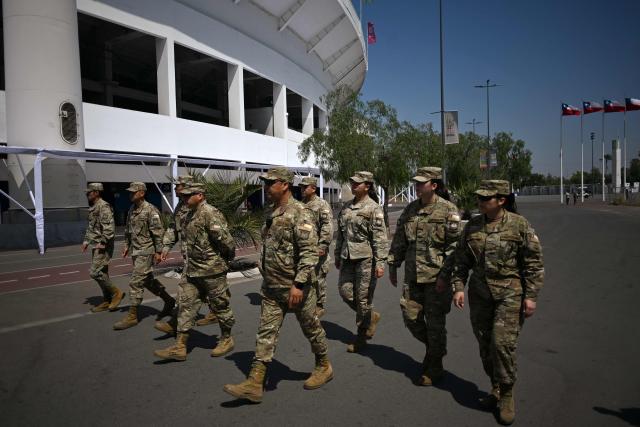 Chile's army officers patrol outside the Estadio Nacional ahead of the second round of the presidential election in Santiago on December 13, 2025. Chile votes in a presidential runoff December 14, 2025, between two sharply different candidates: Jeannette Jara, a communist backed by a broad left coalition, and Jose Antonio Kast, a devout far-right politico promising a hard line on security and migration. (Photo by EITAN ABRAMOVICH / AFP)
