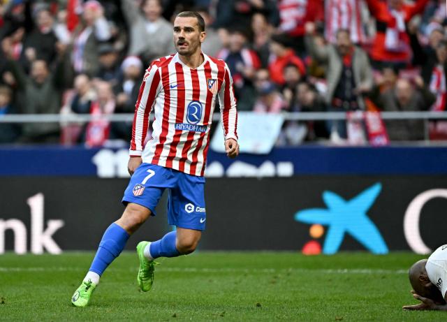 TOPSHOT - Atletico Madrid's French forward #07 Antoine Griezmann celebrates scoring his team's second goal next to Valencia's French defender # 20 Dimitri Foulquier during the Spanish league football match between Club Atletico de Madrid and Valencia CF at Metropolitano Stadium in Madrid on December 13, 2025. (Photo by Javier SORIANO / AFP)
