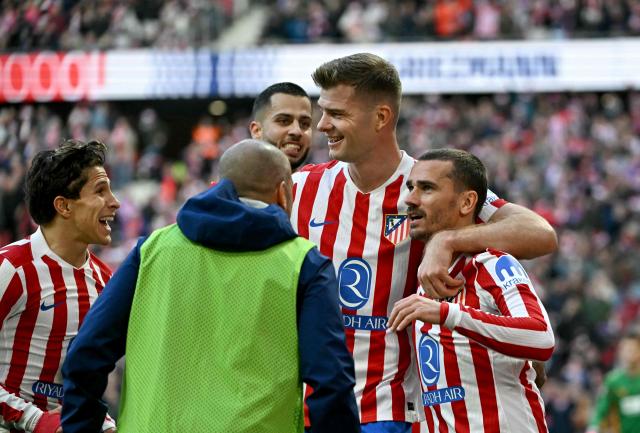 Atletico Madrid's French forward #07 Antoine Griezmann celebrates scoring his team's second goal with Atletico Madrid's Norwegian forward #09 Alexander Sorloth and Atletico Madrid's Argentine forward #20 Giuliano Simeone (L) during the Spanish league football match between Club Atletico de Madrid and Valencia CF at Metropolitano Stadium in Madrid on December 13, 2025. (Photo by Javier SORIANO / AFP)