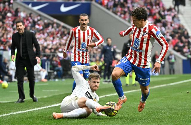Atletico Madrid's Argentine forward #20 Giuliano Simeone fights for the ball with Valencia's Argentinian forward # 15 Lucas Beltran (down) during the Spanish league football match between Club Atletico de Madrid and Valencia CF at Metropolitano Stadium in Madrid on December 13, 2025. (Photo by Javier SORIANO / AFP)