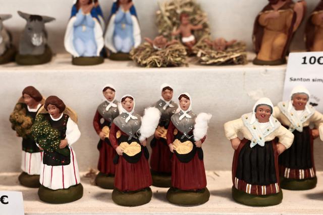 This photograph shows traditional Provencal santon small hand-painted terracotta figurines representing the Christmas nativity scene, traditional in the Provence region, on display at a stand at "La Foire aux Santons" (the Santons' fair) at the Vieux Port in Marseille, southeastern France on December 13, 2025. Santons are small, hand-painted terracotta figurines representing the traditional Provencal Christmas nativity scene. (Photo by Thibaud MORITZ / AFP)