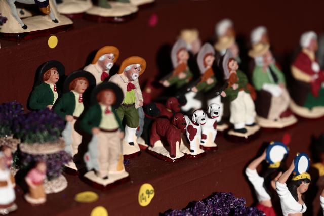 This photograph shows traditional Provencal santon small hand-painted terracotta figurines representing the Christmas nativity scene, traditional in the Provence region, on display at a stand at "La Foire aux Santons" (the Santons' fair) at the Vieux Port in Marseille, southeastern France on December 13, 2025. Santons are small, hand-painted terracotta figurines representing the traditional Provencal Christmas nativity scene. (Photo by Thibaud MORITZ / AFP)