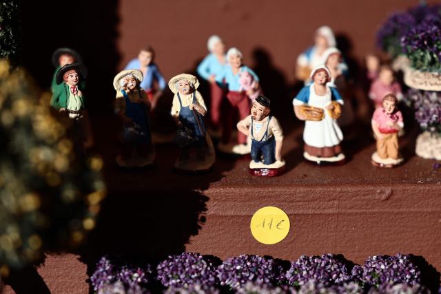 This photograph shows traditional Provencal santon small hand-painted terracotta figurines representing the Christmas nativity scene, traditional in the Provence region, on display at a stand at "La Foire aux Santons" (the Santons' fair) at the Vieux Port in Marseille, southeastern France on December 13, 2025. Santons are small, hand-painted terracotta figurines representing the traditional Provencal Christmas nativity scene. (Photo by Thibaud MORITZ / AFP)