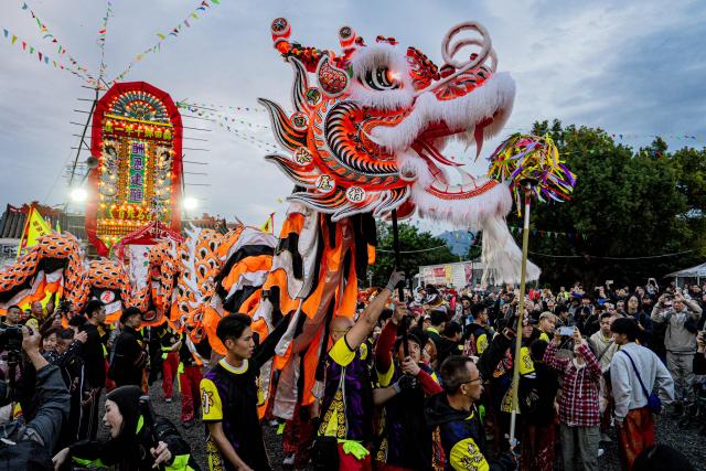 People perform dragon and lion dances during the decennial Jiao Festival of Kam Tin in Hong Kong on December 13, 2025. The Taoist ritual, held once every ten years, is performed to give thanks to deities, ward off misfortune and pray for peace and prosperity in the community. (Photo by Leung Man Hei / AFP)
