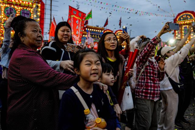 Visitors watch dragon and lion dance performances during the decennial Jiao Festival of Kam Tin in Hong Kong on December 13, 2025. The Taoist ritual, held once every ten years, is performed to give thanks to deities, ward off misfortune and pray for peace and prosperity in the community. (Photo by Leung Man Hei / AFP)