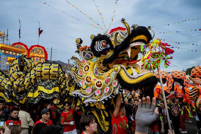 People perform dragon and lion dances during the decennial Jiao Festival of Kam Tin in Hong Kong on December 13, 2025. The Taoist ritual, held once every ten years, is performed to give thanks to deities, ward off misfortune and pray for peace and prosperity in the community. (Photo by Leung Man Hei / AFP)