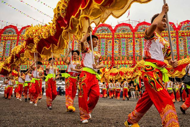 People perform dragon and lion dances during the decennial Jiao Festival of Kam Tin in Hong Kong on December 13, 2025. The Taoist ritual, held once every ten years, is performed to give thanks to deities, ward off misfortune and pray for peace and prosperity in the community. (Photo by Leung Man Hei / AFP)