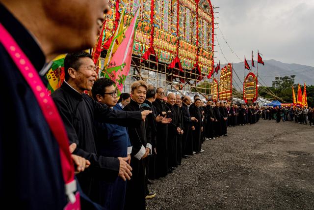 People attend the decennial Jiao Festival of Kam Tin in Hong Kong on December 13, 2025. The Taoist ritual, held once every ten years, is performed to give thanks to deities, ward off misfortune and pray for peace and prosperity in the community. (Photo by Leung Man Hei / AFP)