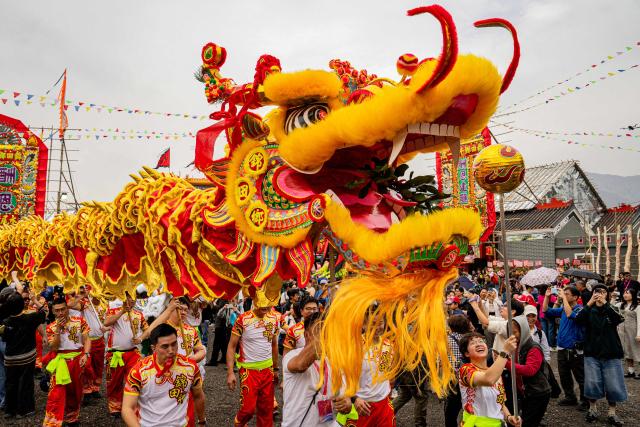 People perform dragon and lion dances during the decennial Jiao Festival of Kam Tin in Hong Kong on December 13, 2025. The Taoist ritual, held once every ten years, is performed to give thanks to deities, ward off misfortune and pray for peace and prosperity in the community. (Photo by Leung Man Hei / AFP)