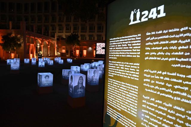 A general view of an exhibition displaying portraits of 241 young victims of the war in Gaza at Msheireb Museums in Doha on December 13, 2025. The exhibition organised by Qatar Charity features 241 portraits of sponsored orphan children cared for through the compassion of donors, bringing their presence into a space where their names, faces and stories can be known and remembered. (Photo by Mahmud HAMS / AFP)