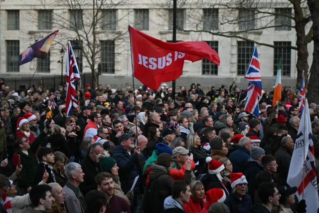 Supporters of British far-right activist Tommy Robinson, whose real name is Stephen Yaxley-Lennon, gather on Whitehall in central London on December 13, 2025, to hold an outdoor carol concert. (Photo by JUSTIN TALLIS / AFP)