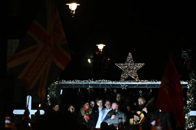 British far-right activist Tommy Robinson, whose real name is Stephen Yaxley-Lennon, addresses supporters gathered to listen to him speak on stage, on Whitehall in central London on December 13, 2025, an outdoor carol concert event he organised. (Photo by JUSTIN TALLIS / AFP)