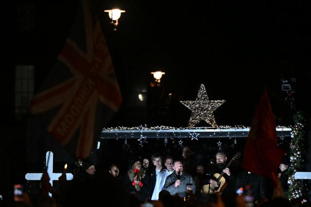 British far-right activist Tommy Robinson, whose real name is Stephen Yaxley-Lennon, addresses supporters gathered to listen to him speak on stage, on Whitehall in central London on December 13, 2025, an outdoor carol concert event he organised. (Photo by JUSTIN TALLIS / AFP)