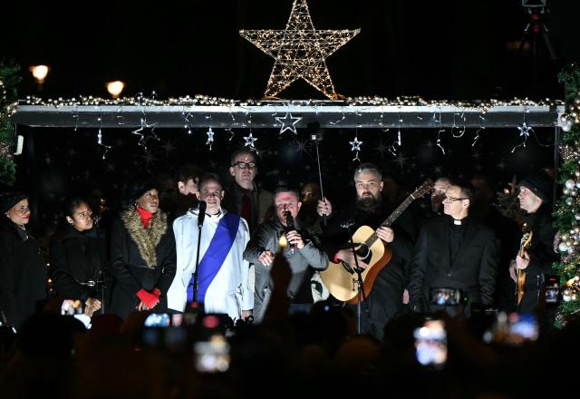 British far-right activist Tommy Robinson, whose real name is Stephen Yaxley-Lennon, addresses supporters gathered to listen to him speak on stage, on Whitehall in central London on December 13, 2025, an outdoor carol concert event he organised. (Photo by JUSTIN TALLIS / AFP)