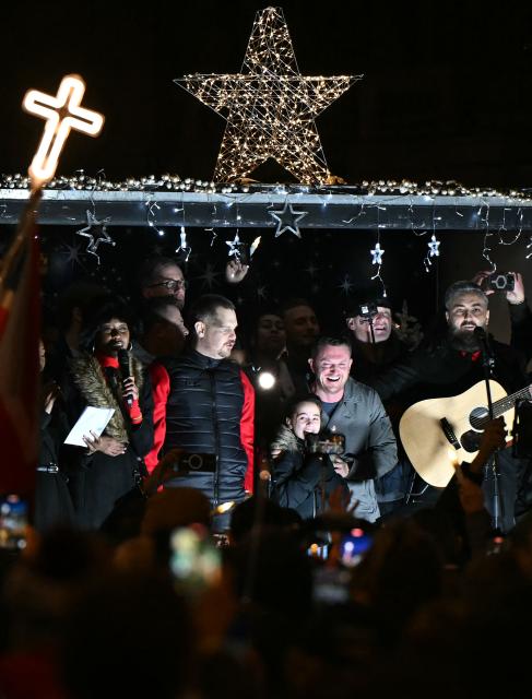 British far-right activist Tommy Robinson, whose real name is Stephen Yaxley-Lennon, addresses supporters gathered to listen to him speak on stage, on Whitehall in central London on December 13, 2025, an outdoor carol concert event he organised. (Photo by JUSTIN TALLIS / AFP)