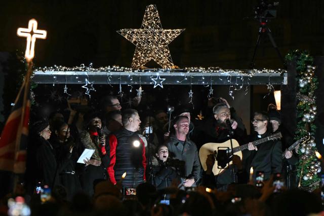 British far-right activist Tommy Robinson, whose real name is Stephen Yaxley-Lennon, sings after addressing supporters gathered to listen to him speak on stage, on Whitehall in central London on December 13, 2025, an outdoor carol concert event he organised. (Photo by JUSTIN TALLIS / AFP)