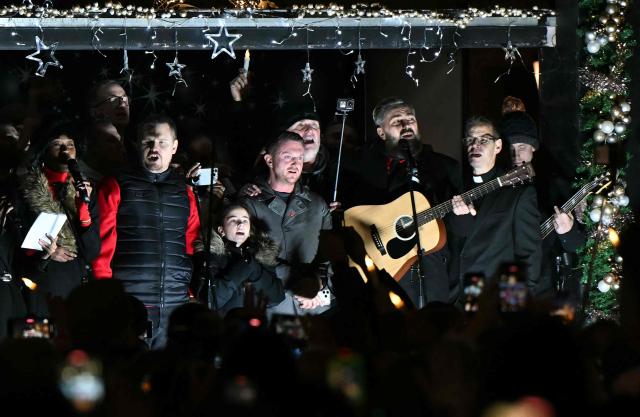 British far-right activist Tommy Robinson, whose real name is Stephen Yaxley-Lennon, sings after addressing supporters gathered to listen to him speak on stage, on Whitehall in central London on December 13, 2025, an outdoor carol concert event he organised. (Photo by JUSTIN TALLIS / AFP)