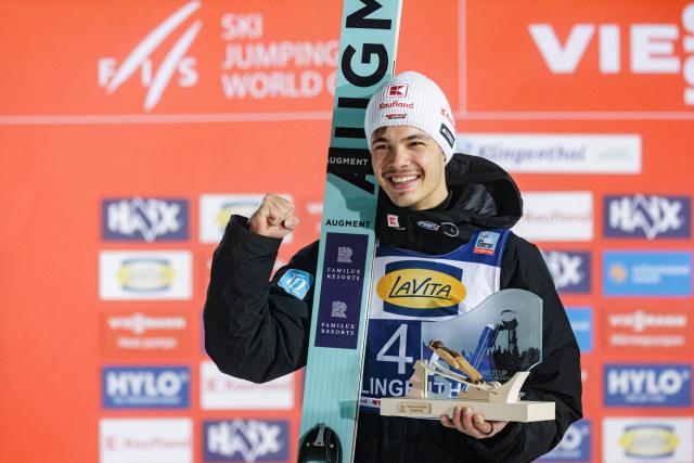 Third placed placed Germany's Raimund Philipp celebrates on the podium after winning the Men's Individual Large Hill HS140 event of the FIS Ski Jumping World Cup in Klingenthal, eastern Germany on December 13, 2025. Slovenia's Domen Prevc won the event ahead of Austria's Stefan Kraft (2nd) and Germany's Philipp Raimund (3rd). (Photo by JENS SCHLUETER / AFP)