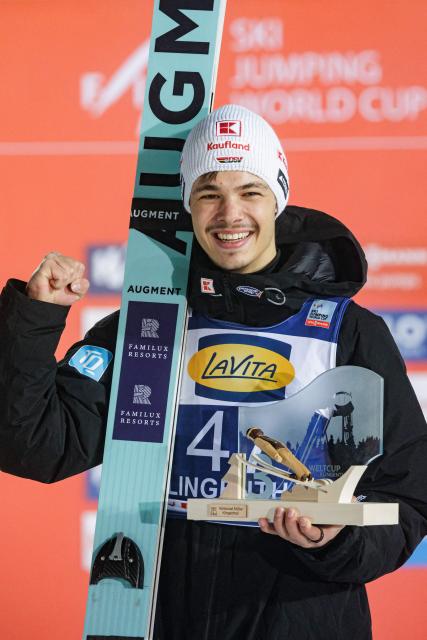 Third placed placed Germany's Raimund Philipp celebrates on the podium after winning the Men's Individual Large Hill HS140 event of the FIS Ski Jumping World Cup in Klingenthal, eastern Germany on December 13, 2025. Slovenia's Domen Prevc won the event ahead of Austria's Stefan Kraft (2nd) and Germany's Philipp Raimund (3rd). (Photo by JENS SCHLUETER / AFP)