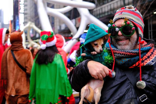 Revellers take part in the 2025 SantaCon NYC pub crawl for charity in New York on December 13, 2025. Proceeds from tickets and donations are given to various charities. (Photo by CHARLY TRIBALLEAU / AFP)