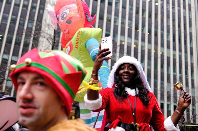 Revellers take part in the 2025 SantaCon NYC pub crawl for charity in New York on December 13, 2025. Proceeds from tickets and donations are given to various charities. (Photo by CHARLY TRIBALLEAU / AFP)