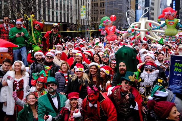 Revellers take part in the 2025 SantaCon NYC pub crawl for charity in New York on December 13, 2025. Proceeds from tickets and donations are given to various charities. (Photo by CHARLY TRIBALLEAU / AFP)