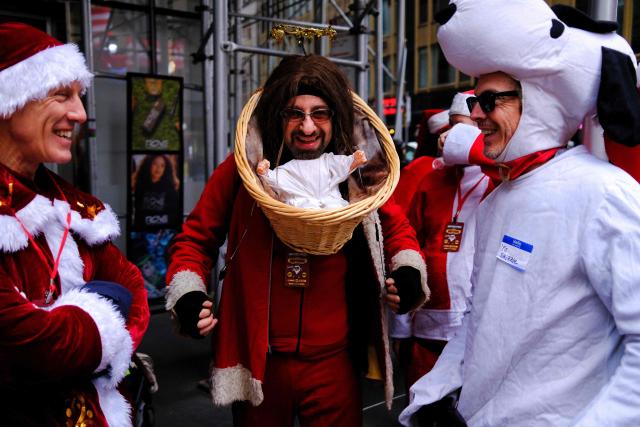 Revellers take part in the 2025 SantaCon NYC pub crawl for charity in New York on December 13, 2025. Proceeds from tickets and donations are given to various charities. (Photo by CHARLY TRIBALLEAU / AFP)