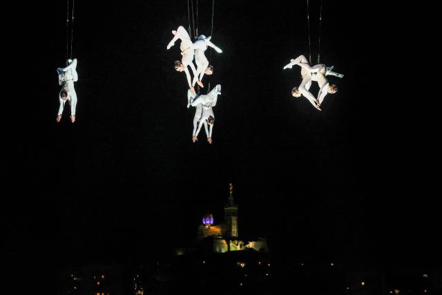 Members of the Zenit dance company perform an aerial ballet titled 'ARIA' above spectators in the old port of Marseille, southern France, during the city’s Christmas celebrations, on December 13, 2025. (Photo by Thibaud MORITZ / AFP)