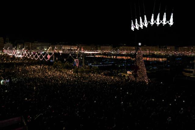 TOPSHOT - Members of the Zenit dance company perform an aerial ballet titled 'ARIA' above spectators in the old port of Marseille, southern France, during the city’s Christmas celebrations, on December 13, 2025. (Photo by Thibaud MORITZ / AFP)