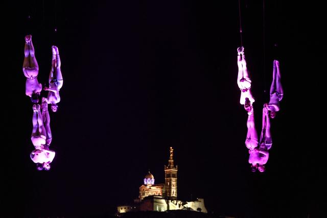 Members of the Zenit dance company perform an aerial ballet titled 'ARIA' above spectators in the old port of Marseille, southern France, during the city’s Christmas celebrations, on December 13, 2025. (Photo by Thibaud MORITZ / AFP)