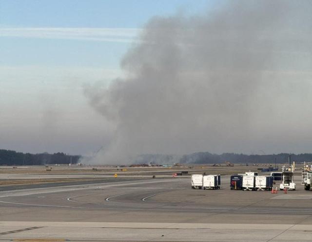 This picture provided by Houman David Hemmati shows smoke billowing on a runway at Dulles International Airport in Virginia on December 13, 2025 after a United Airlines flight bound for Tokyo returned to the airport shortly after takeoff following a reported engine fire. (Photo by Houman David Hemmati / @houmanhemmati / AFP)