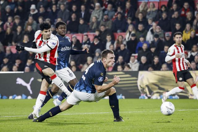 Heracles Almelo's Dutch forward #09 Jizz Hornkamp (L) kicks the ball in front of PSV Eindhoven's Dutch defender #04 Armando Obispo during the Dutch Eredivisie match between PSV Eindhoven and Heracles Almelo at the Phillips Stadium on December 11, 2025 in Eindhoven, Netherlands. (Photo by MAURICE VAN STEEN / ANP / AFP) / Netherlands OUT