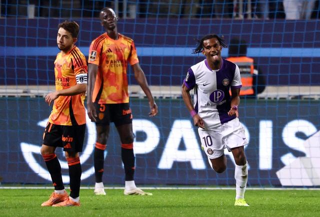 Toulouse's French forward #10 Yann Gboho (R) celebrates after scoring his team second goal during the French L1 football match between Paris FC and Toulouse FC at the Stade Jean-Bouin in Paris on December 13, 2025. (Photo by FRANCK FIFE / AFP)