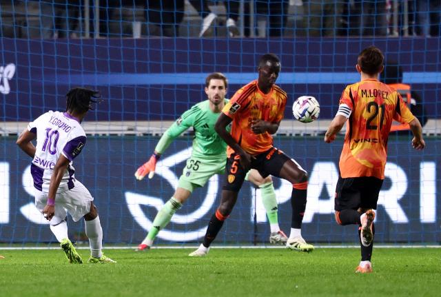 Toulouse's French forward #10 Yann Gboho (L) shoots and scores his team second goal during the French L1 football match between Paris FC and Toulouse FC at the Stade Jean-Bouin in Paris on December 13, 2025. (Photo by FRANCK FIFE / AFP)