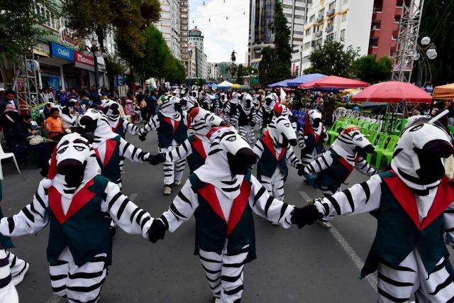 Artists dressed as zebras take part in a Christmas parade in La Paz on December 13, 2025. (Photo by Jorge BERNAL / AFP)