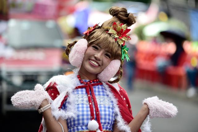An artist gestures as she takes part in a Christmas parade in La Paz on December 13, 2025. (Photo by Jorge BERNAL / AFP)