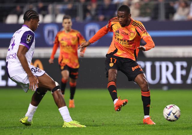 Paris FC's French midfielder #17 Adama Camara (R) passes the ball during the French L1 football match between Paris FC and Toulouse FC at the Stade Jean-Bouin in Paris on December 13, 2025. (Photo by FRANCK FIFE / AFP)