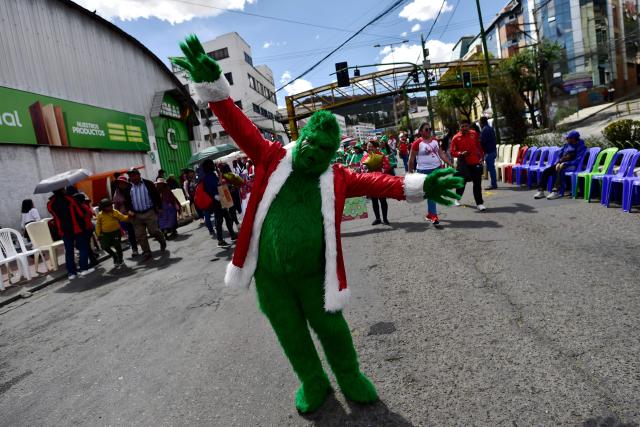 An artist dressed as the Grinch gestures as he takes part in a Christmas parade in La Paz on December 13, 2025. (Photo by Jorge BERNAL / AFP)