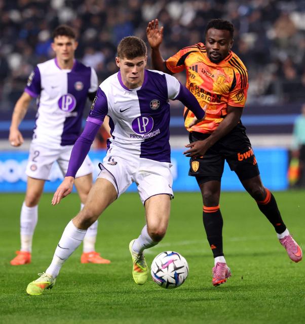 Paris FC's Nigerian forward #27 Moses Simon (R) fights for the ball with Toulouse's English defender #04 Charlie Cresswell during the French L1 football match between Paris FC and Toulouse FC at the Stade Jean-Bouin in Paris on December 13, 2025. (Photo by FRANCK FIFE / AFP)