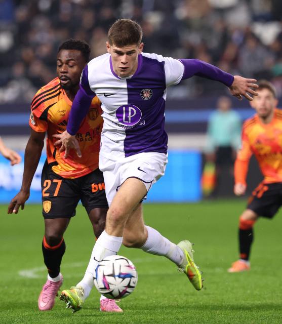Paris FC's Nigerian forward #27 Moses Simon (R) fights for the ball with Toulouse's English defender #04 Charlie Cresswell during the French L1 football match between Paris FC and Toulouse FC at the Stade Jean-Bouin in Paris on December 13, 2025. (Photo by FRANCK FIFE / AFP)