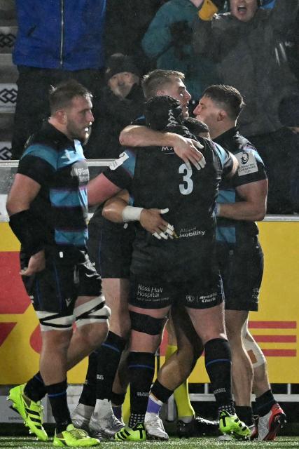 Glasgow players celebrate their third try during the European Champions Cup rugby union pool 1 match between Glasgow Warriors and Toulouse at Scotstoun Stadium in Glasgow, Scotland on December 13, 2025. (Photo by ANDY BUCHANAN / AFP)