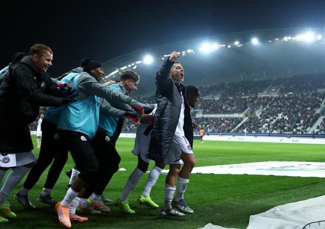 Toulouse's French forward #10 Yann Gboho (R) celebrates his goal with teammates during the French L1 football match between Paris FC and Toulouse FC at the Stade Jean-Bouin in Paris on December 13, 2025. (Photo by FRANCK FIFE / AFP)