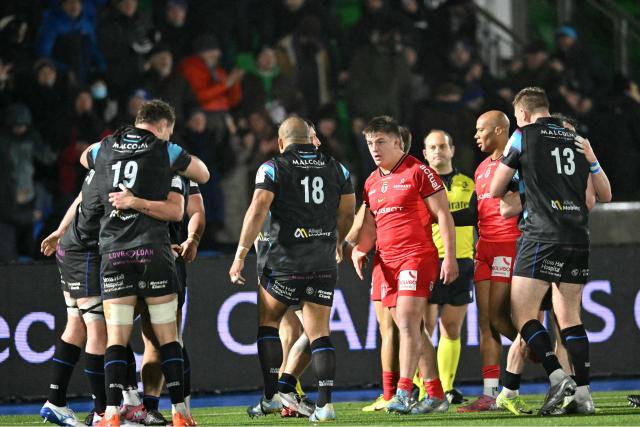 Glasgow players celebrate on the final whistle in the European Champions Cup rugby union pool 1 match between Glasgow Warriors and Toulouse at Scotstoun Stadium in Glasgow, Scotland on December 13, 2025. Glasgow won the game 28-21 after being 0-21 down at half-time. (Photo by ANDY BUCHANAN / AFP)