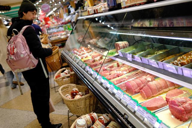 People shop for meat in a grocery store in the Manhattan borough of New York City on December 13, 2025. (Photo by CHARLY TRIBALLEAU / AFP)