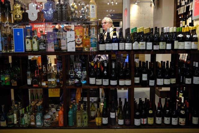 People shop in a liquor store in the Manhattan borough of New York City on December 13, 2025. (Photo by CHARLY TRIBALLEAU / AFP)