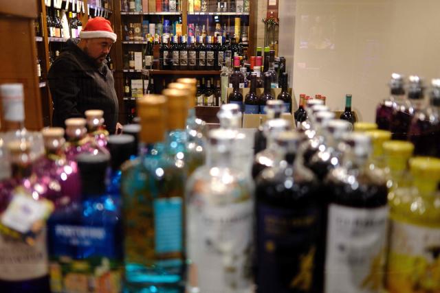 People shop in a liquor store in the Manhattan borough of New York City on December 13, 2025. (Photo by CHARLY TRIBALLEAU / AFP)