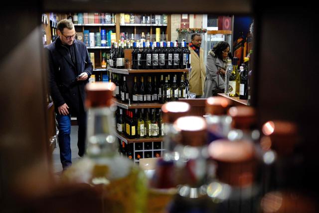 People shop in a liquor store in the Manhattan borough of New York City on December 13, 2025. (Photo by CHARLY TRIBALLEAU / AFP)